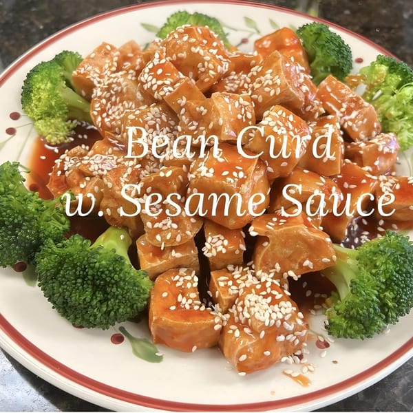 Close-up of China Star's bean curd with sesame sauce and broccoli on a decorative plate.
