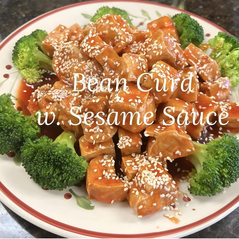 Close-up of China Star's bean curd with sesame sauce and broccoli on a decorative plate.